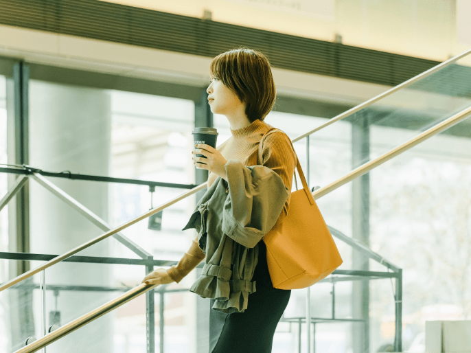 飲み物を持った女性が立っている写真