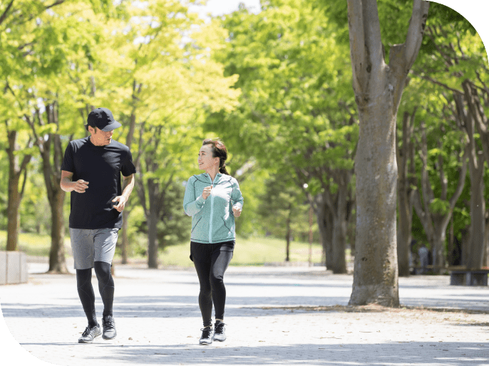 男女が緑の中をジョギングしている写真