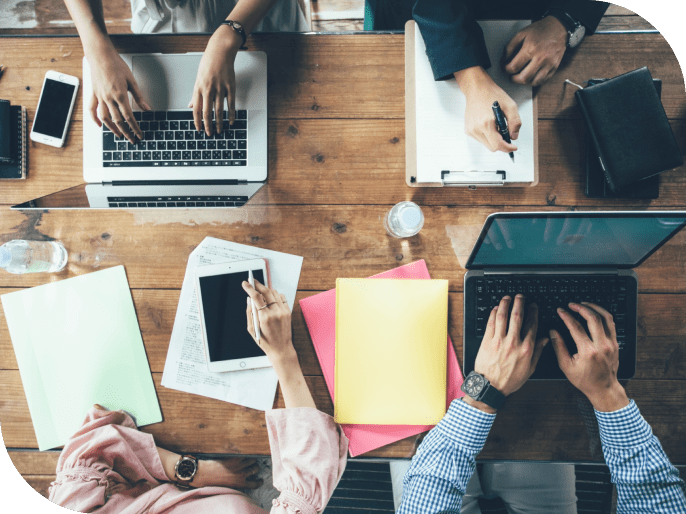 ４人で机を囲んで作業をしている写真