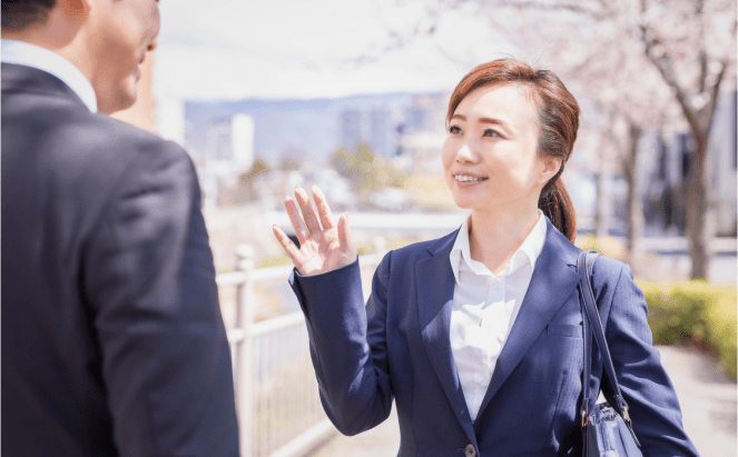 スーツ姿の男女が会話している写真