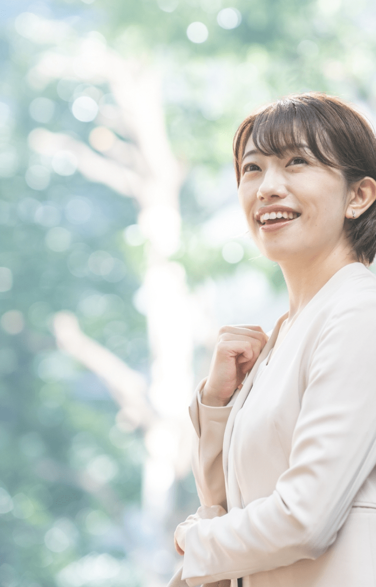 白いスーツの女性が微笑んでいる写真