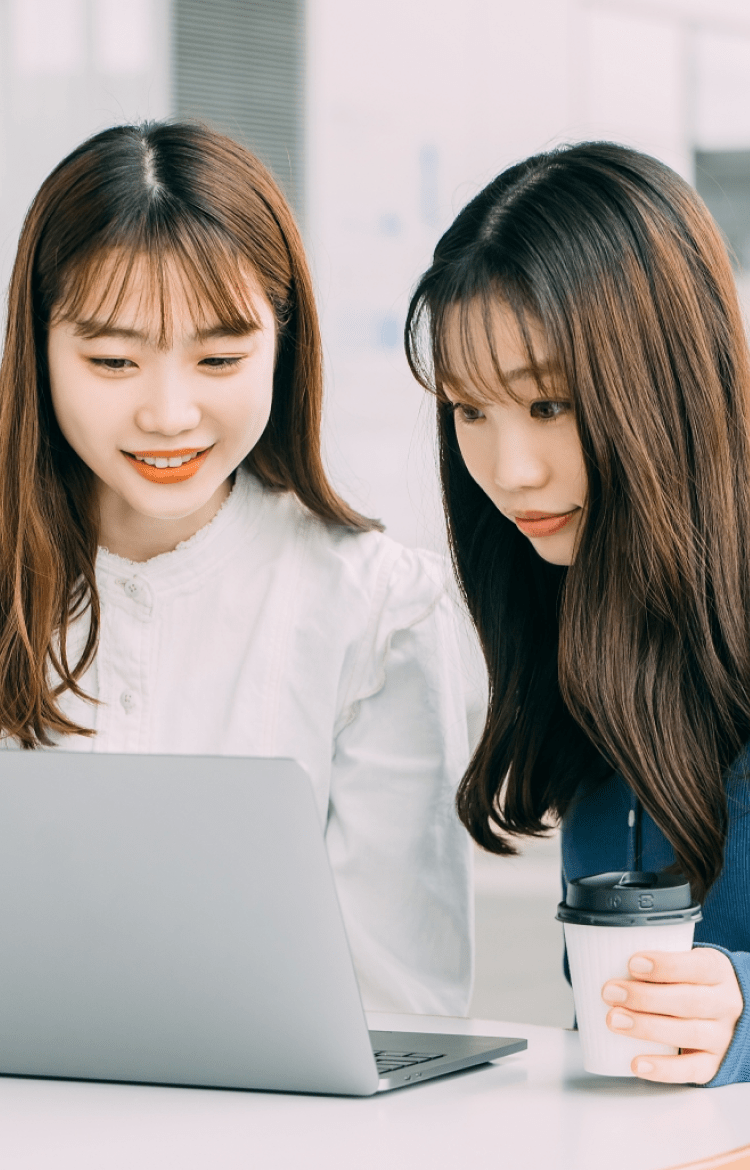 女性二人がパソコンを見ている写真